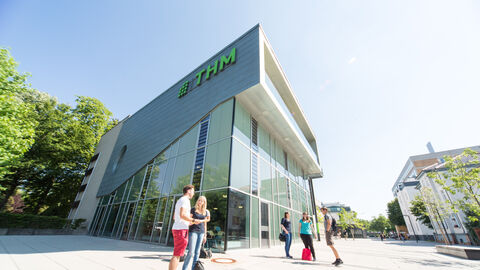 Studenten stehen vor einem Gebäude der THM.